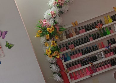 Vibrant nail polish display at Luv Ur Nails, Roseau, Saint George Parish, DM, with floral decor.