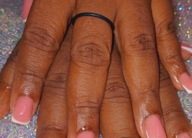Close-up of French manicure at Luv Ur Nails in Roseau, Saint George Parish, DM, on a glittery background.