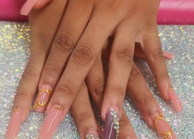 Elegant nail art at Luv Ur Nails, Roseau, Saint George Parish, DM featuring long nails with gold and gem designs.