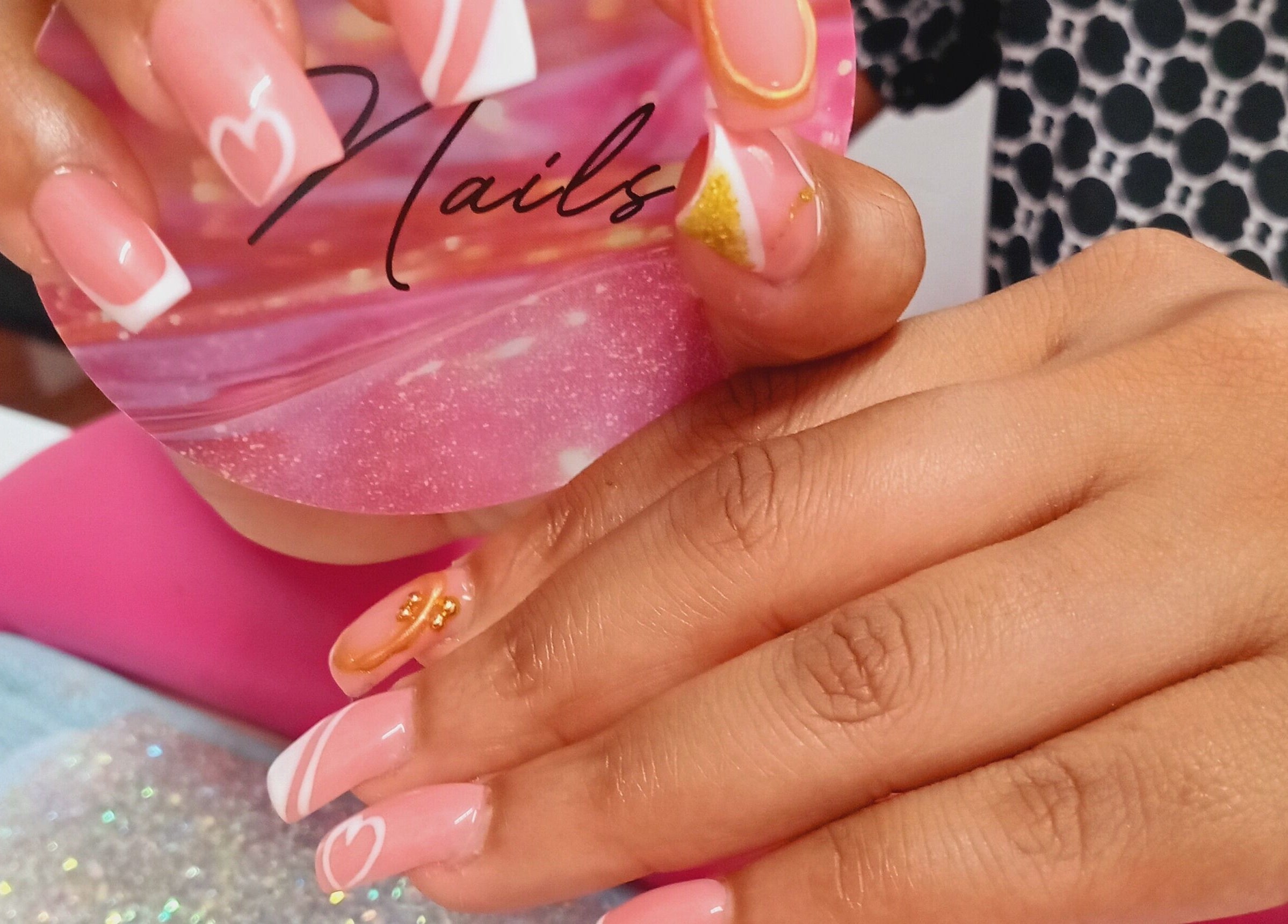 Elegant nail art at Luv Ur Nails in Roseau, Saint George Parish, DM. Pink manicure with heart and stripe details.