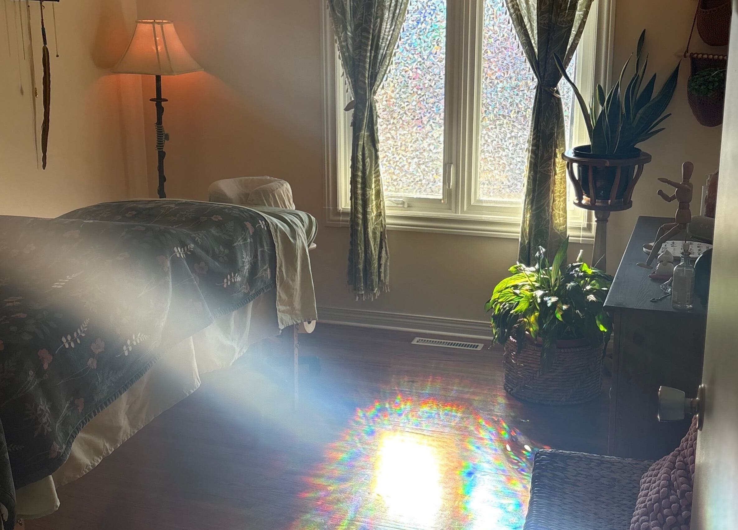Tranquil massage room at Bliss Point Massage, Calgary, Alberta, CA, with sunlight streaming through the window.