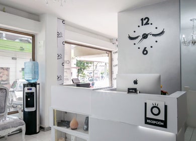 Recepción moderna en Chicago Beauty, Medellín, Antioquia, CO con reloj decorativo y silla elegante.
