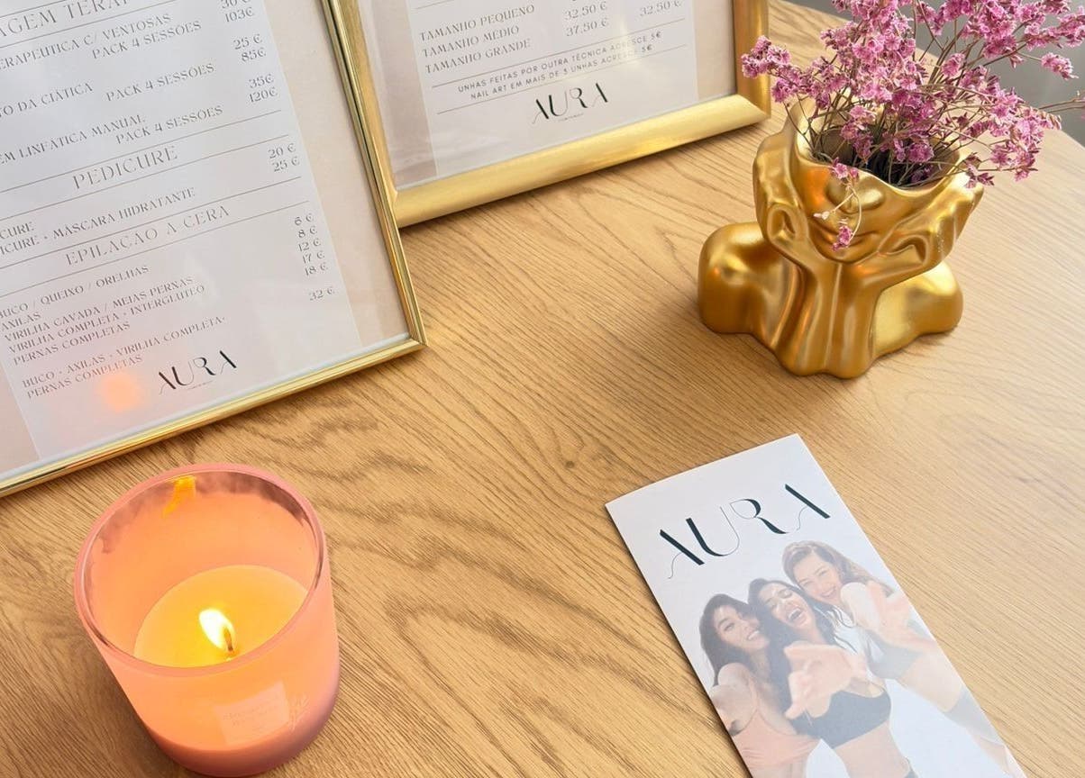 Mesa elegante no Aura - Centro de beleza em Pinhal Novo, Setúbal, PT com menu emoldurado e decoração floral.