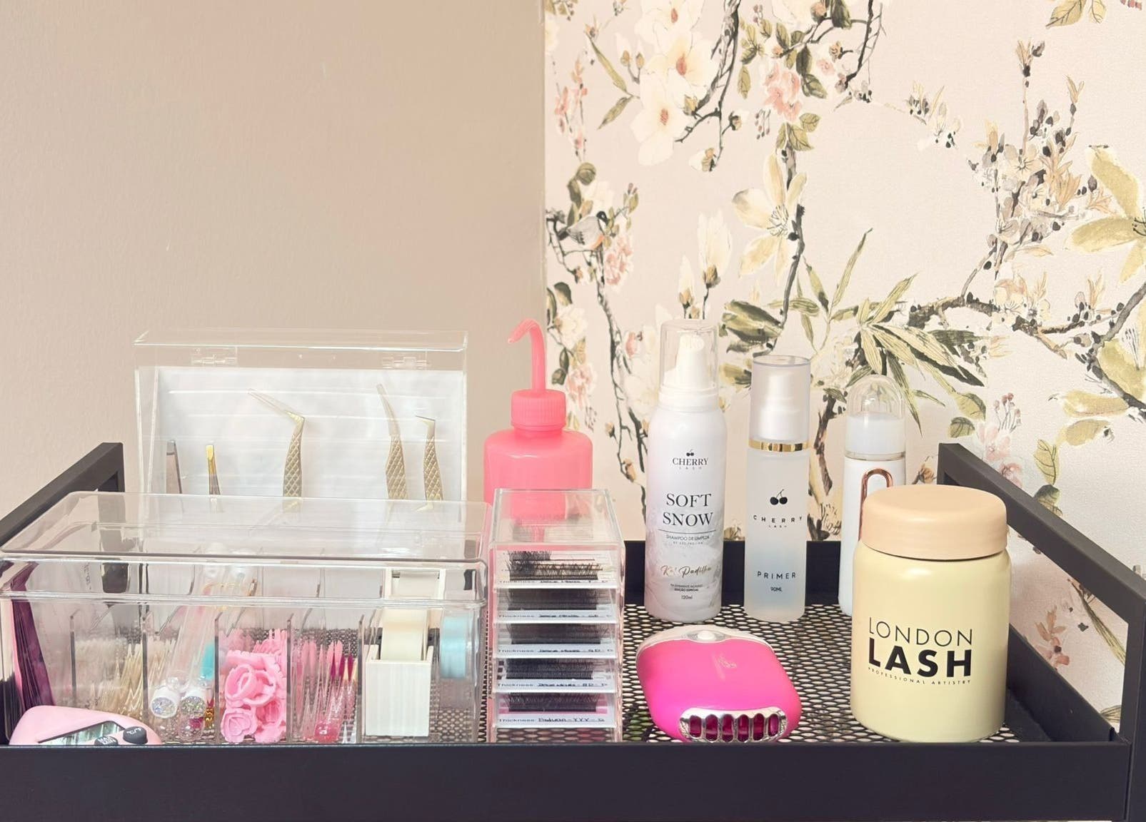 Produtos de beleza organizados na Aura - Centro de beleza, Pinhal Novo, Setúbal, PT, com fundo floral.