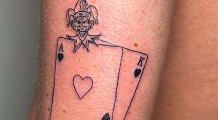 Unique joker and card tattoo at Nail and Needle Clinic, Great Warley, England, GB. Bold and artistic design.