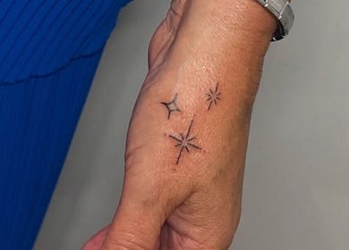 Intricate star tattoo on hand at Nail and Needle Clinic, Great Warley, England, GB.
