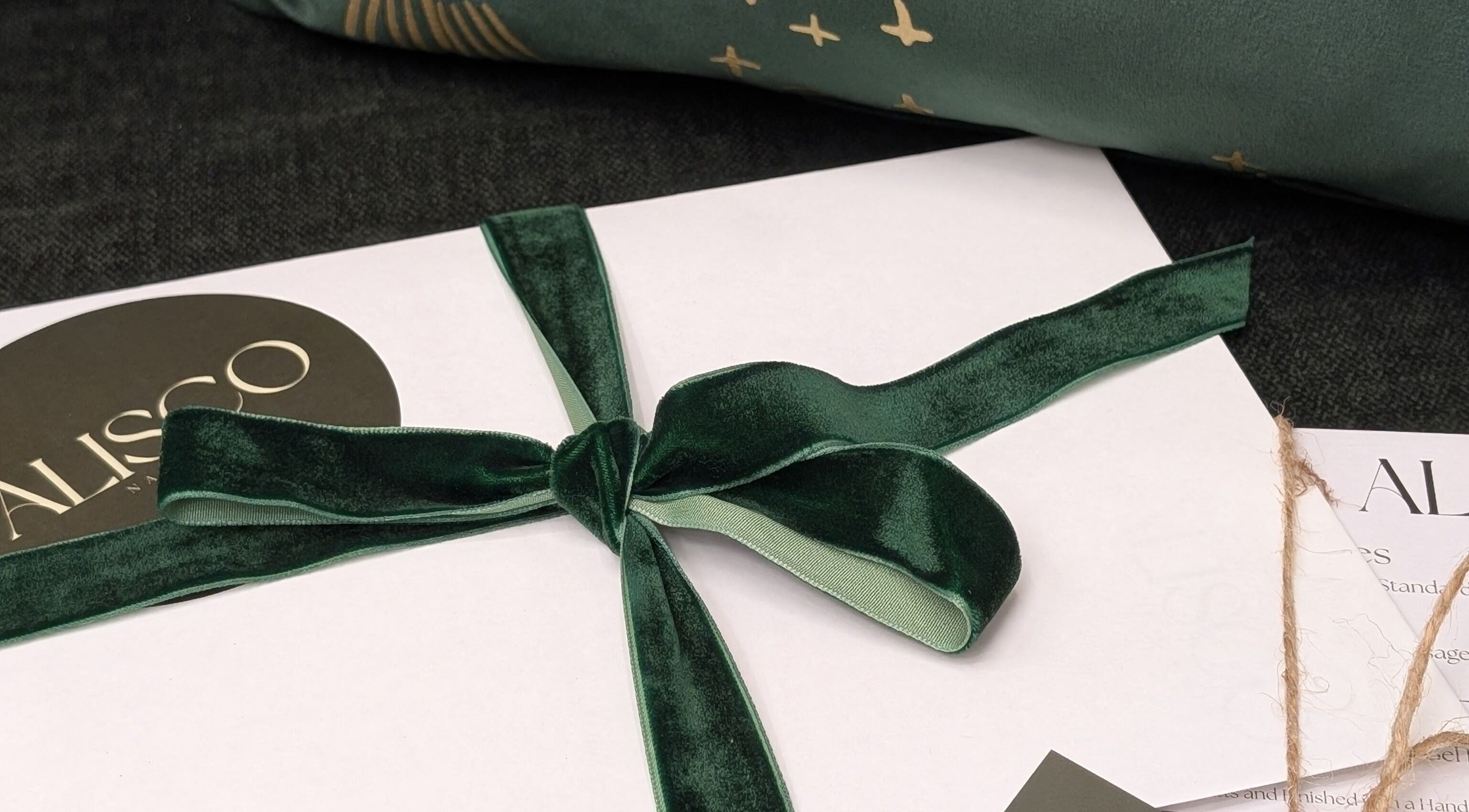 Elegant gift wrap with Alisco Nail Spa branding in Shipley, England, GB. Luxurious green ribbon detail.