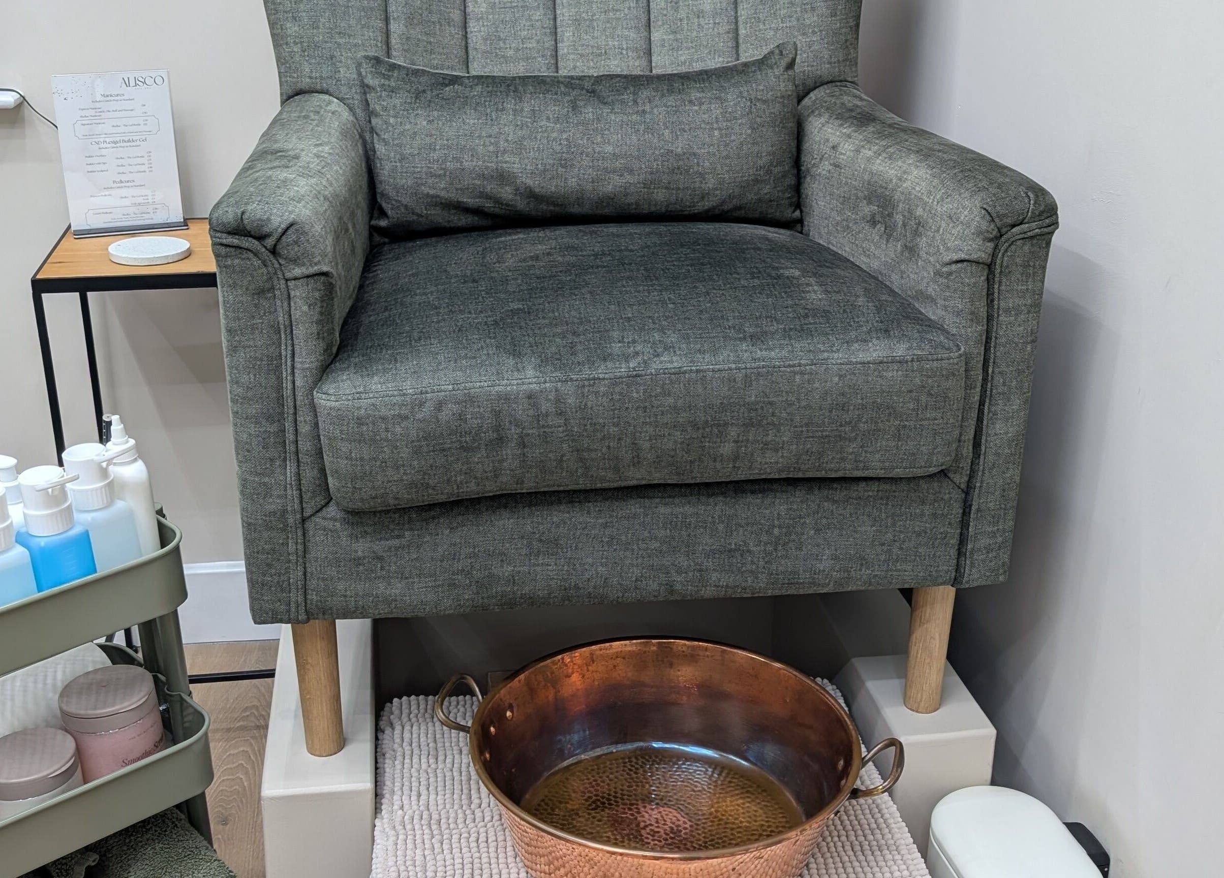 Pedicure station at Alisco Nail Spa, Shipley, England. Features a plush chair and copper basin.