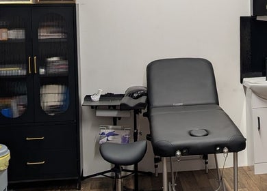 Massage room at Shadow Bloom Studio in Oldham, England, GB with treatment bed and storage cabinet.