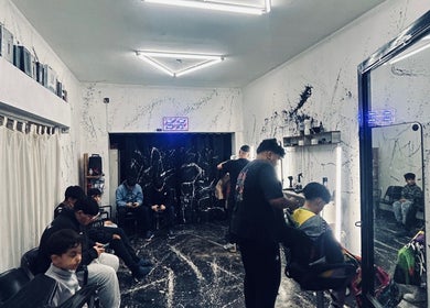 Interior de Barberflow1.0, barbería moderna en Rosario, Santa Fe, AR, con clientes esperando.