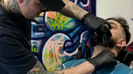 Expert providing a precise beard trim at Jonas Wayne, Norwalk, Connecticut, US, with colorful graffiti backdrop.