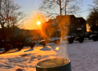 Steam rising from a mug at sunrise in Jonas Wayne, Norwalk, Connecticut, US snowy landscape.
