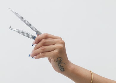 Hand holding tweezers at Mia Lashed in Brampton, Ontario, CA for precision beauty care.