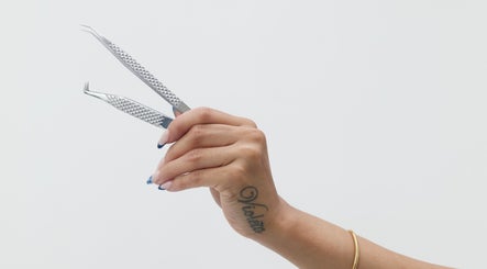 Hand holding tweezers at Mia Lashed in Brampton, Ontario, CA for precision beauty care.