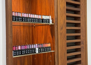 Vibrant nail polish collection at Beautybyalmira, St Albans, England, GB showcasing a stylish wooden shelf.