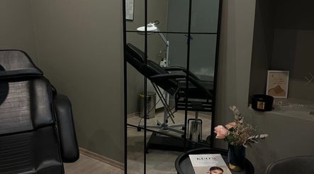 Modern beauty treatment room at Paugurinja.beauty, Rīga, LV, featuring a black chair and elegant decor.