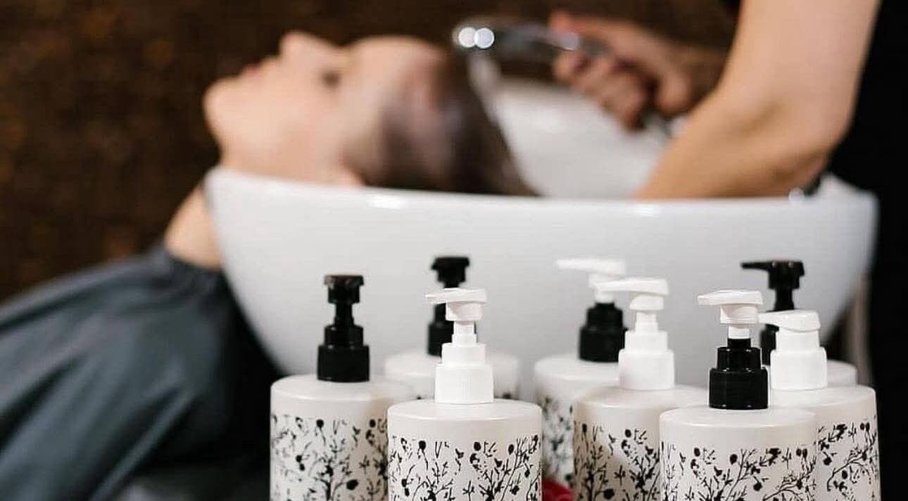 Hair wash service at ditch the box, Gqeberha, Eastern Cape, ZA with shampoo bottles in foreground.