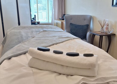Tranquil massage room at Calming-Massage in Blean, England, GB with stones on plush bedding.