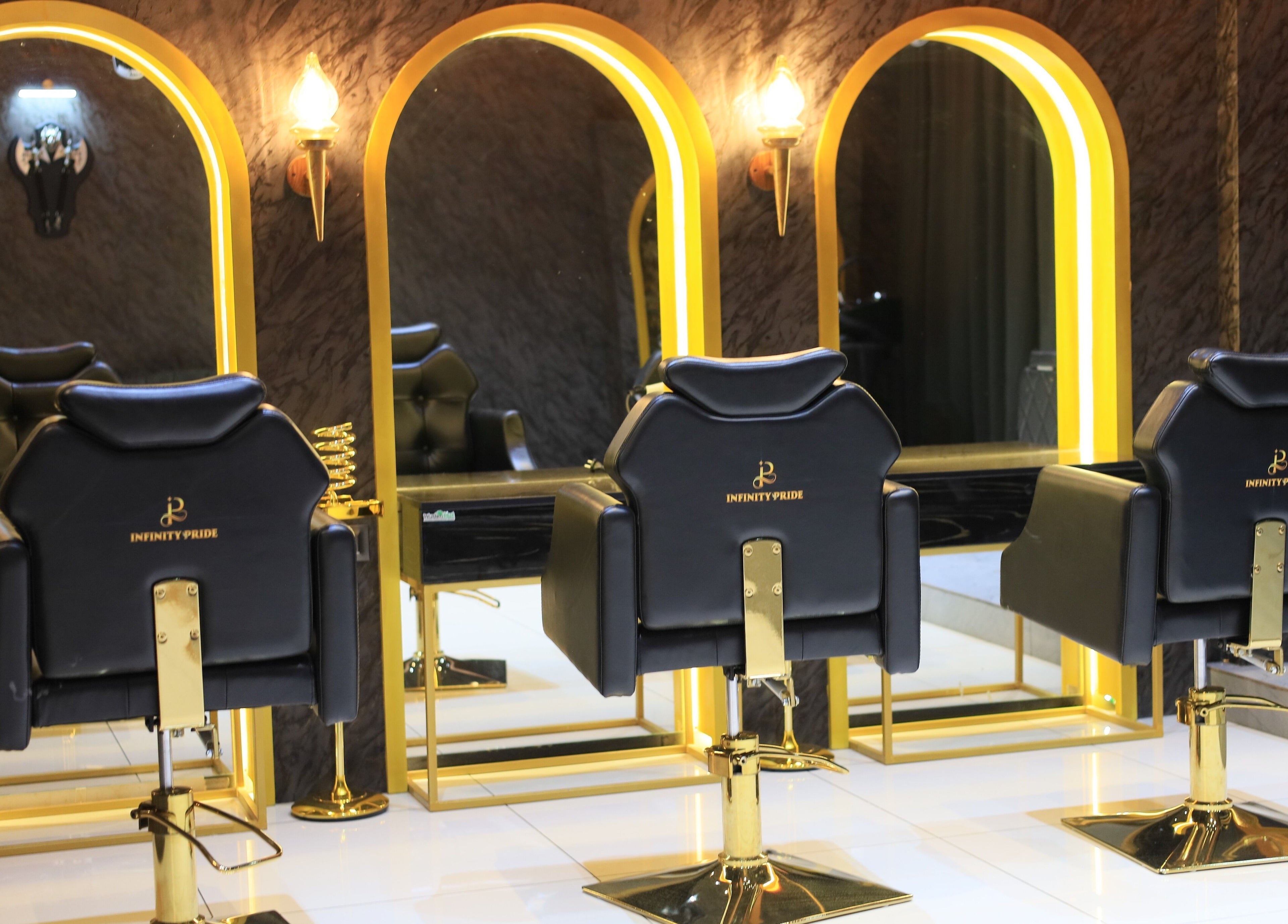 Luxurious salon chairs at Infinity Pride, Kottarakkara, Kerala, IN with elegant gold mirrors.