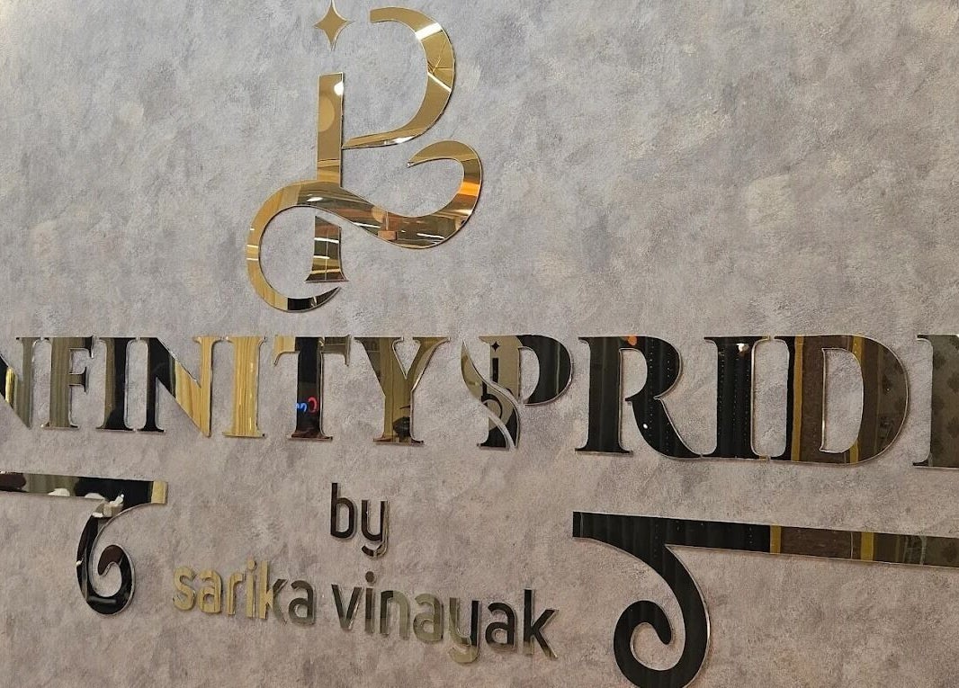 Infinity Pride signage in gold on textured wall, Kottarakkara, Kerala, IN.