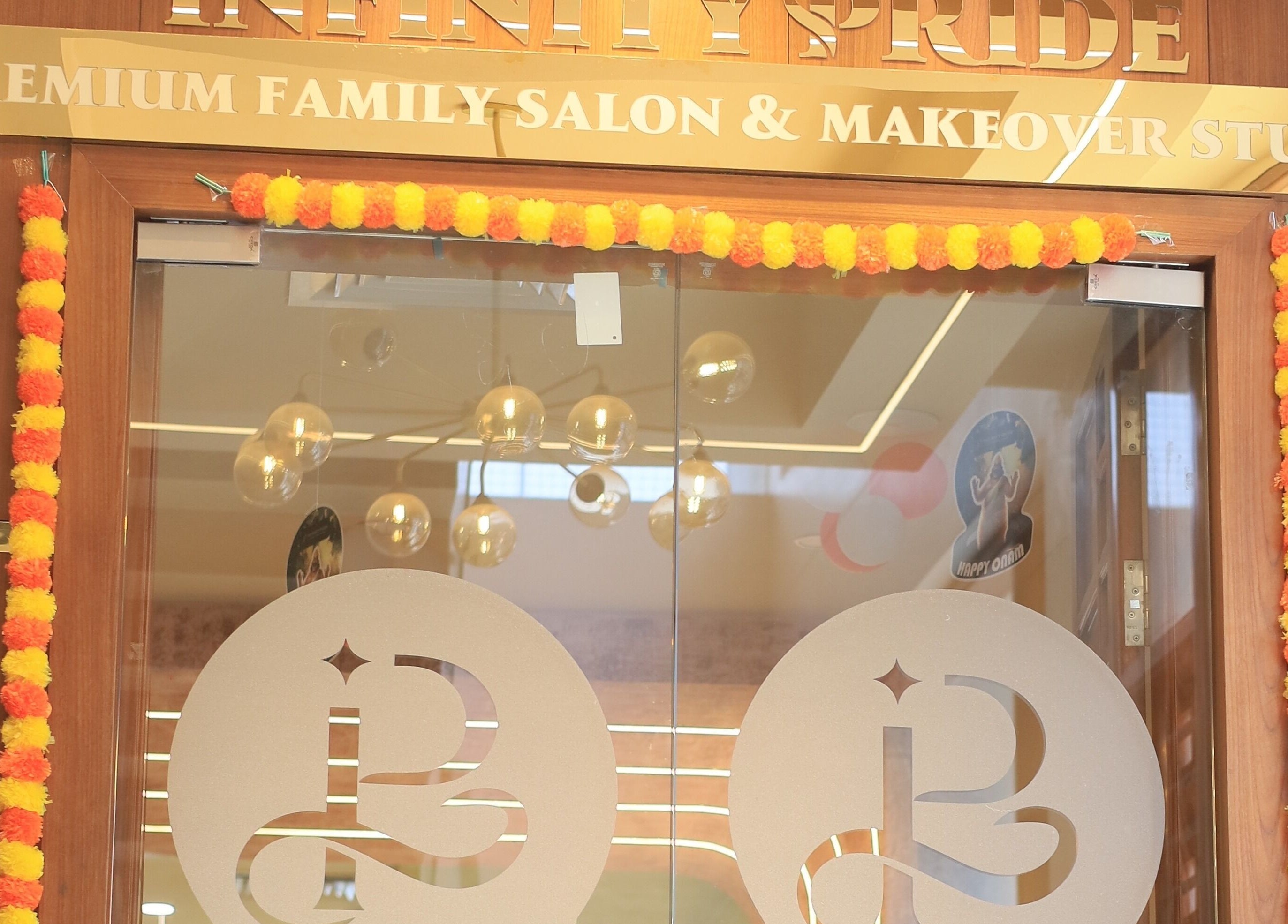 Entrance of Infinity Pride premium family salon in Kottarakkara, Kerala, IN, adorned with festive decor.