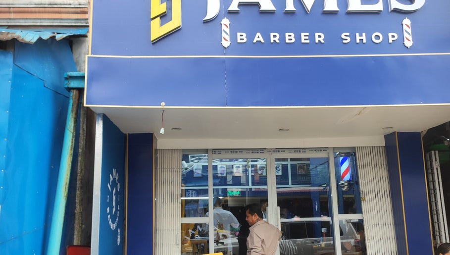 Front view of James Barber Shop in Yangon, showcasing its vibrant blue facade.