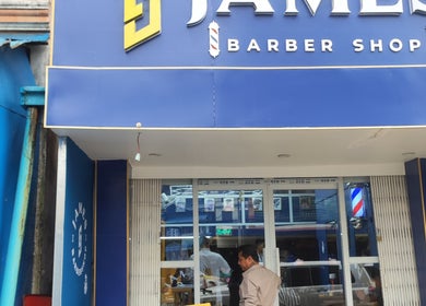 Front view of James Barber Shop in Yangon, showcasing its vibrant blue facade.