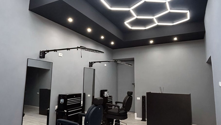 Interni moderni di Carlu barber club, San Maurizio Canavese, Torino, IT con sedie confortevoli e illuminazione elegante.