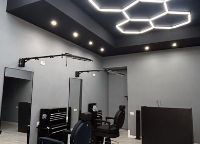 Interni moderni di Carlu barber club, San Maurizio Canavese, Torino, IT con sedie confortevoli e illuminazione elegante.