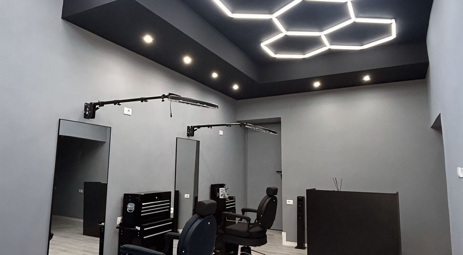 Interni moderni di Carlu barber club, San Maurizio Canavese, Torino, IT con sedie confortevoli e illuminazione elegante.