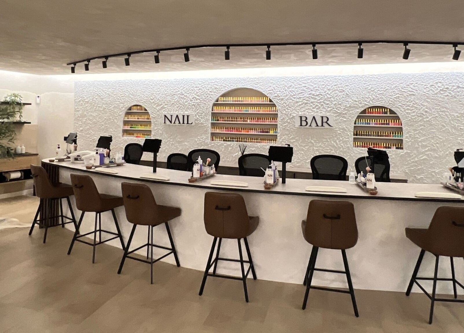 Chic nail bar at Naughty Nails, Birmingham, England, GB with stylish seating and nail polish display.