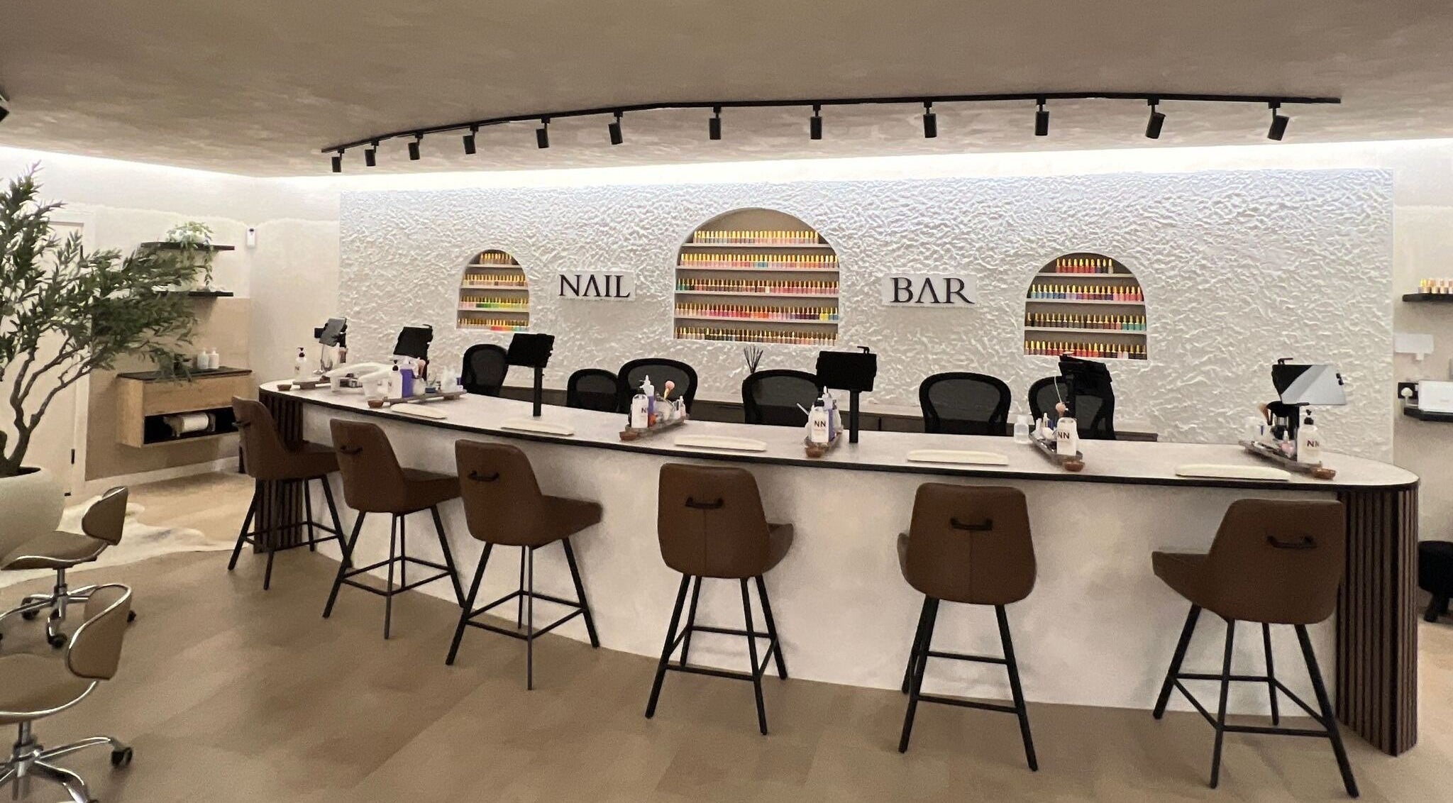 Chic nail bar at Naughty Nails, Birmingham, England, GB with stylish seating and nail polish display.