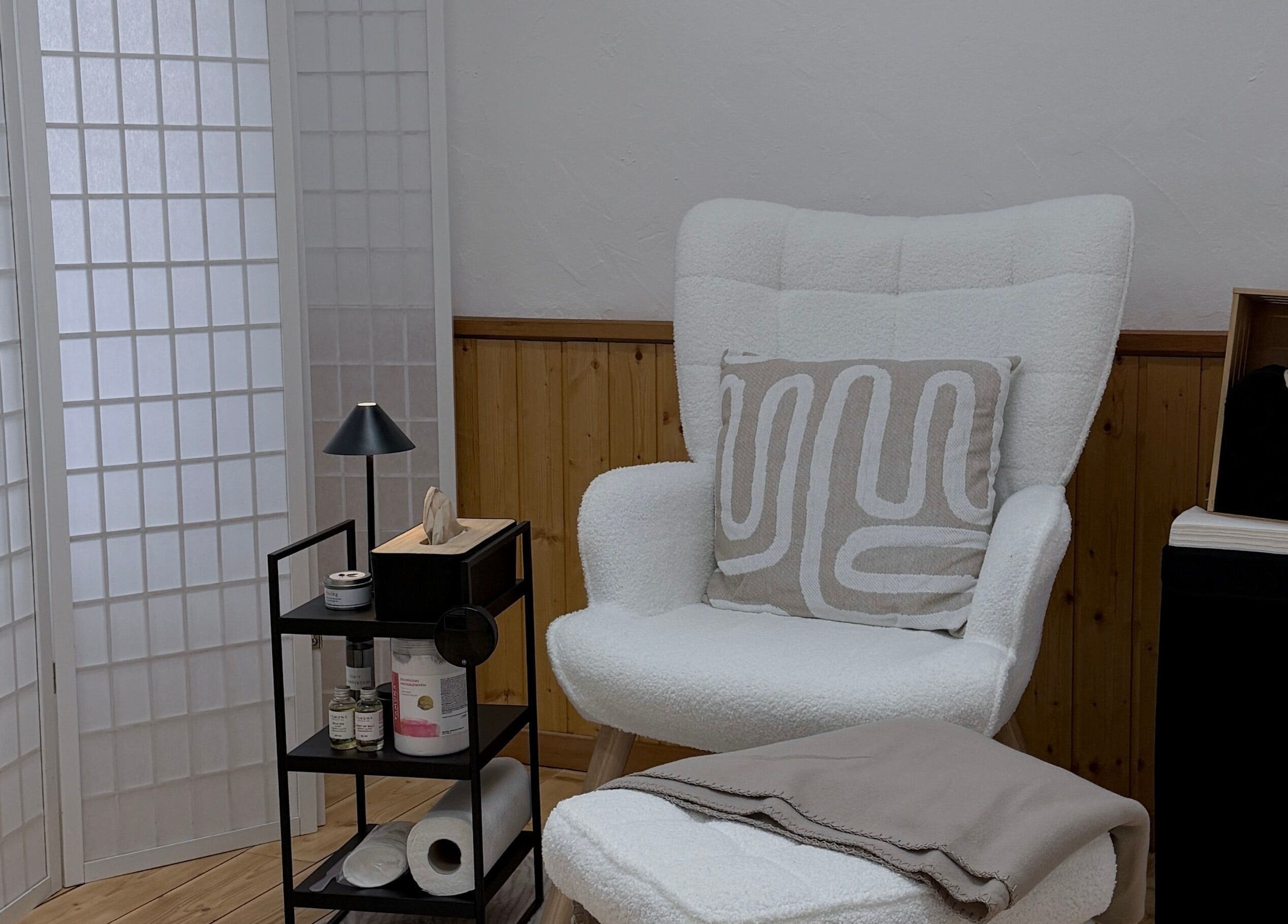 Gemütlicher Behandlungsbereich bei Nude Atelier By Bianka, Scuol, Graubünden, CH, mit einem eleganten Stuhl.