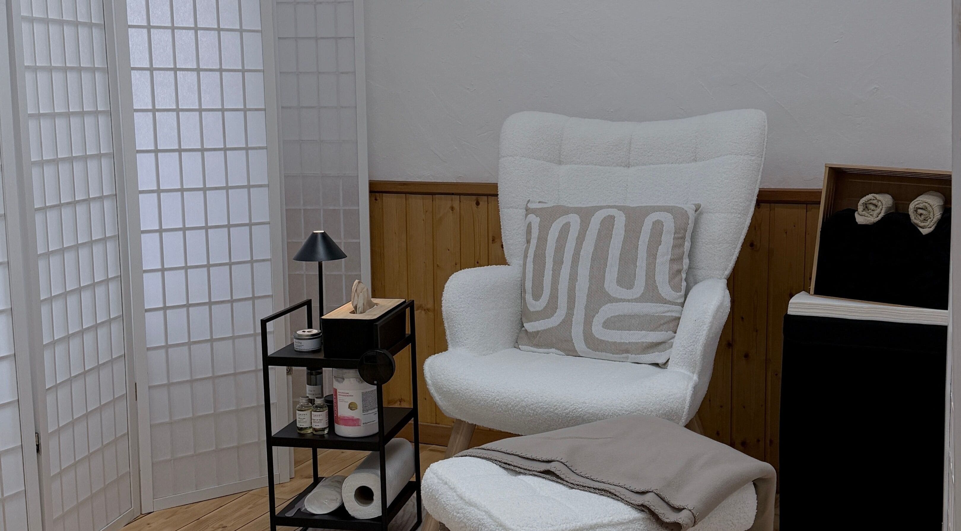 Gemütlicher Behandlungsbereich bei Nude Atelier By Bianka, Scuol, Graubünden, CH, mit einem eleganten Stuhl.