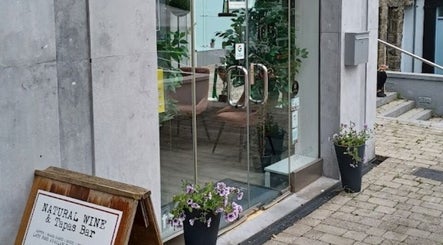 Front glass door entrance to Deeva Nails Westport, County Mayo, IE featuring plants and elegant decor.
