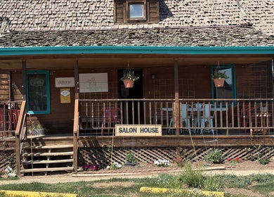 Oceana Beauty's charming wooden salon exterior in Nederland, Colorado, US with welcoming porch and greenery.