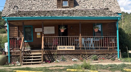 Oceana Beauty's charming wooden salon exterior in Nederland, Colorado, US with welcoming porch and greenery.