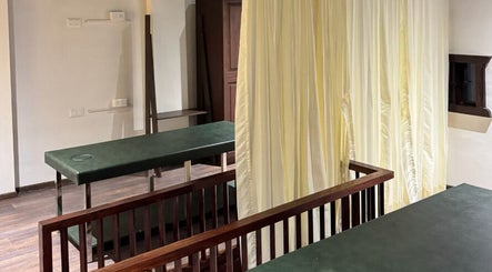 Tranquil massage room with green tables at Gramam Living - Spa, Varkala, Kerala, IN.
