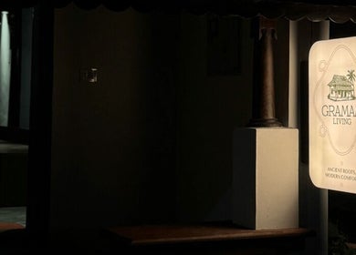 Entrance sign of Gramam Living - Spa, Varkala, Kerala, IN, warmly lit against a dark background.