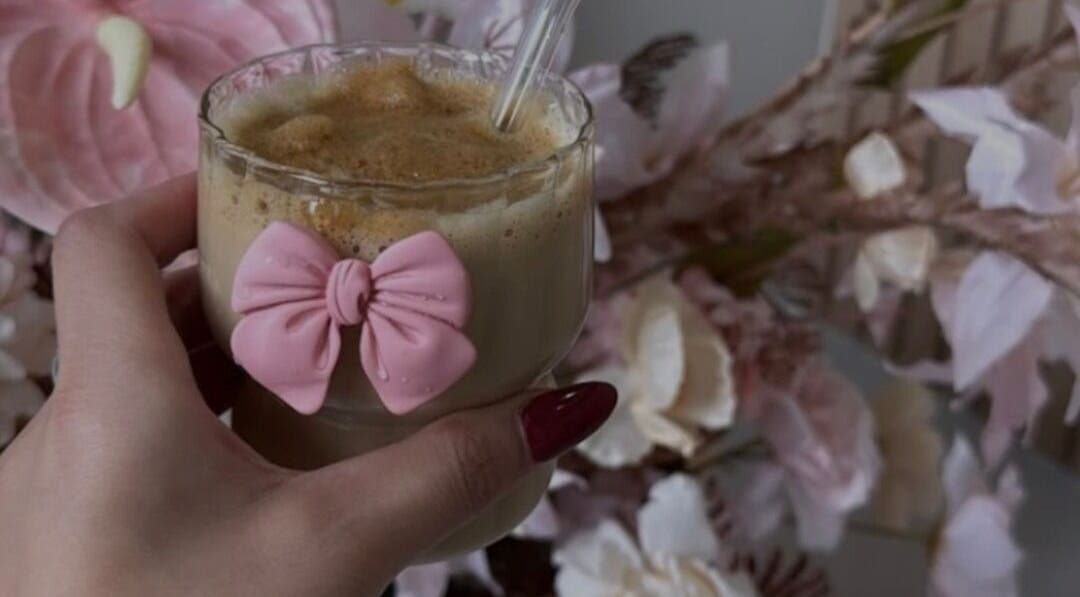 Stylish coffee with pink bow at The Hair Hub, Auckland, NZ surrounded by elegant decor.