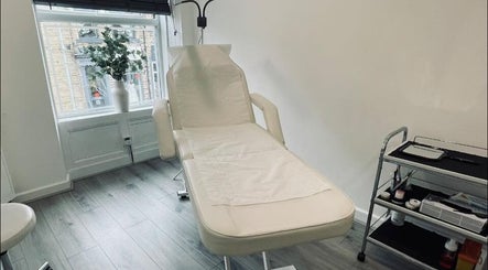 Treatment room at The Definery, Bradford, England, GB with a spa bed and a plant by the window.