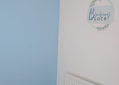 Calm decor at Blueberry Locs Uk, Longfield, England, GB with blue and white walls and stylish logo.