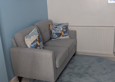Comfy grey sofa with patterned cushions at Blueberry Locs Uk, Longfield, England, GB.