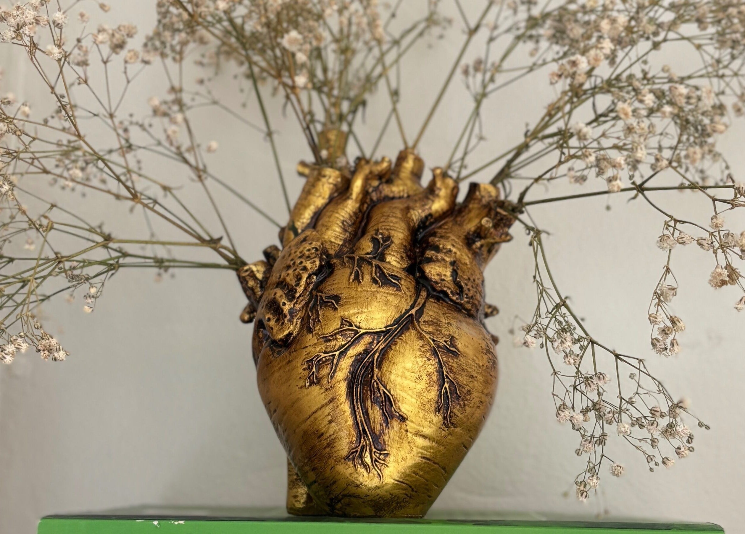 Vaso dourado em forma de coração com flores delicadas no Atelliê 28, Santa Catarina, Santa Catarina, BR.