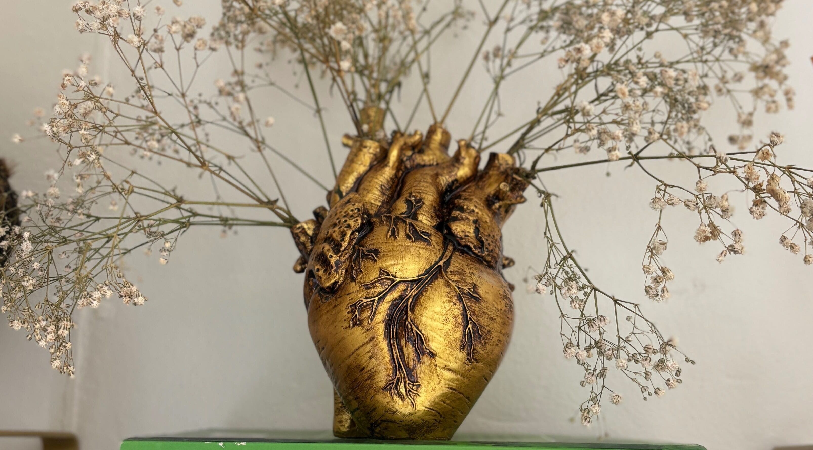 Vaso dourado em forma de coração com flores delicadas no Atelliê 28, Santa Catarina, Santa Catarina, BR.