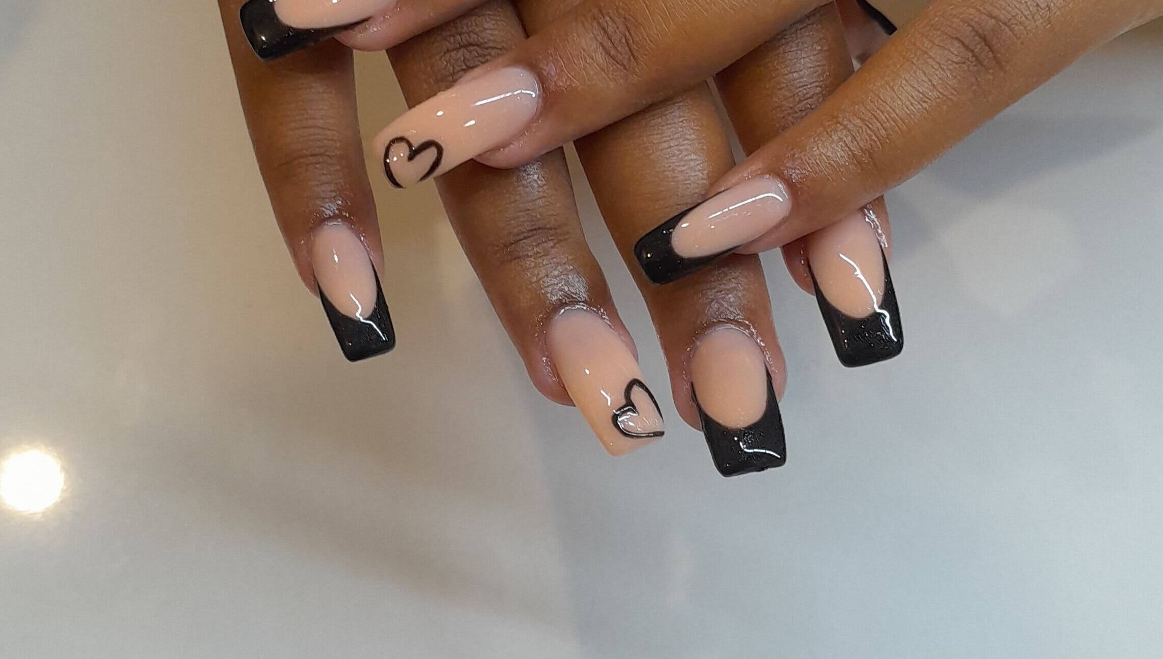 Elegant heart-tipped nails at Emmy's Nails, Cape Town, Western Cape, ZA, showcasing stylish black and nude design.
