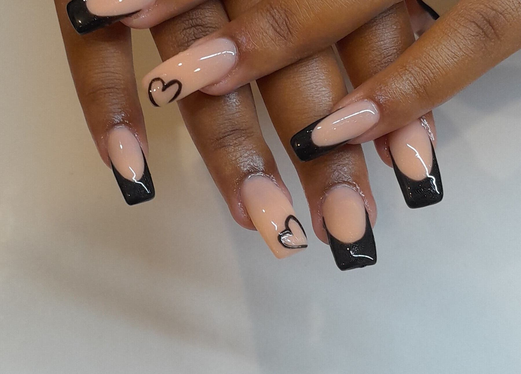Elegant heart-tipped nails at Emmy's Nails, Cape Town, Western Cape, ZA, showcasing stylish black and nude design.