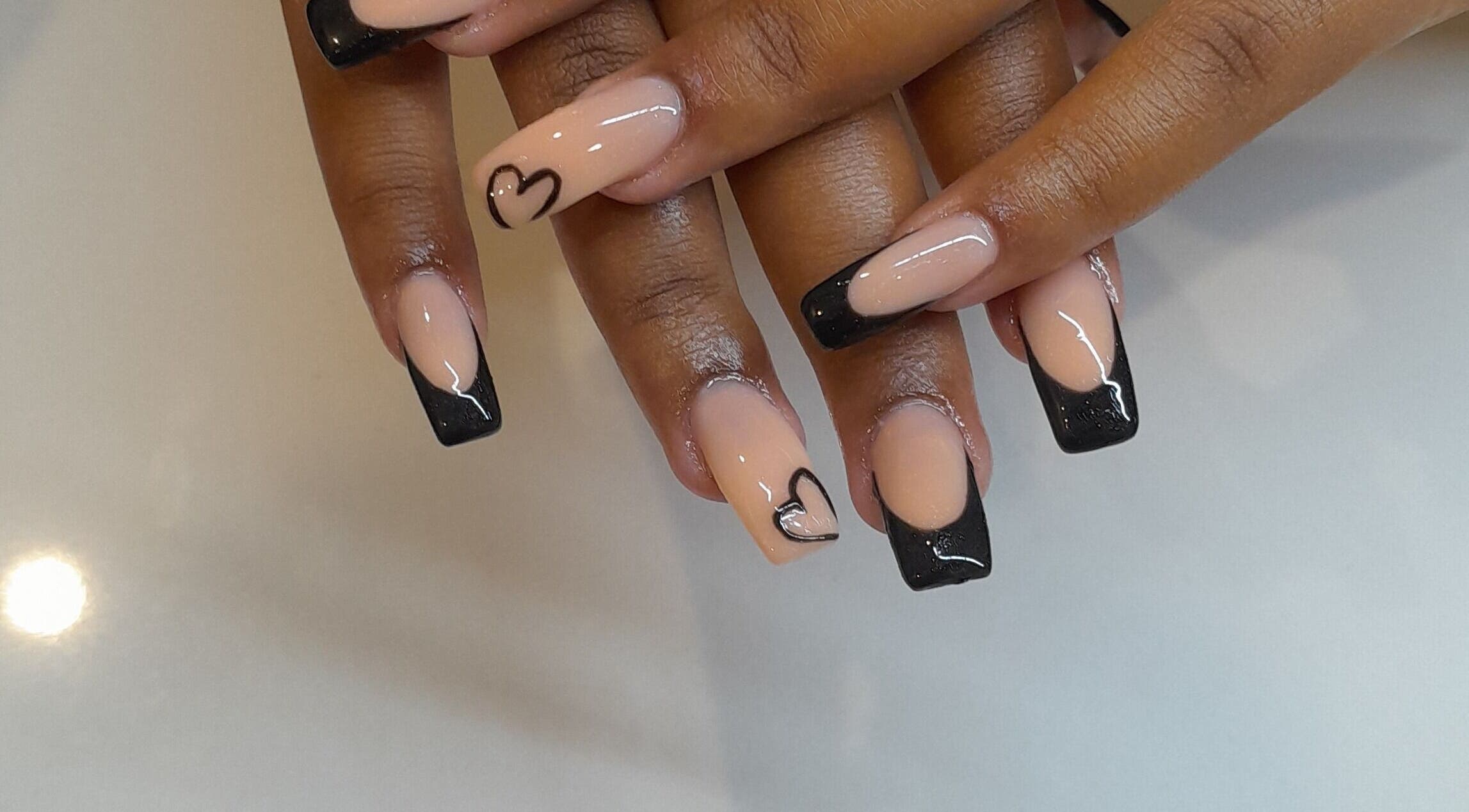 Elegant heart-tipped nails at Emmy's Nails, Cape Town, Western Cape, ZA, showcasing stylish black and nude design.