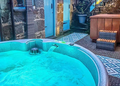 Relaxing outdoor hot tub at Plas Courtyard Spa, Llanbedr, Wales, GB, offering a serene wellness escape.