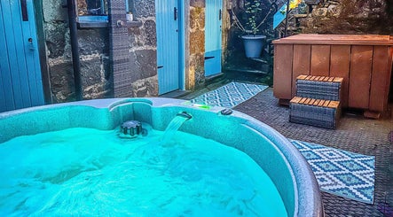 Relaxing outdoor hot tub at Plas Courtyard Spa, Llanbedr, Wales, GB, offering a serene wellness escape.